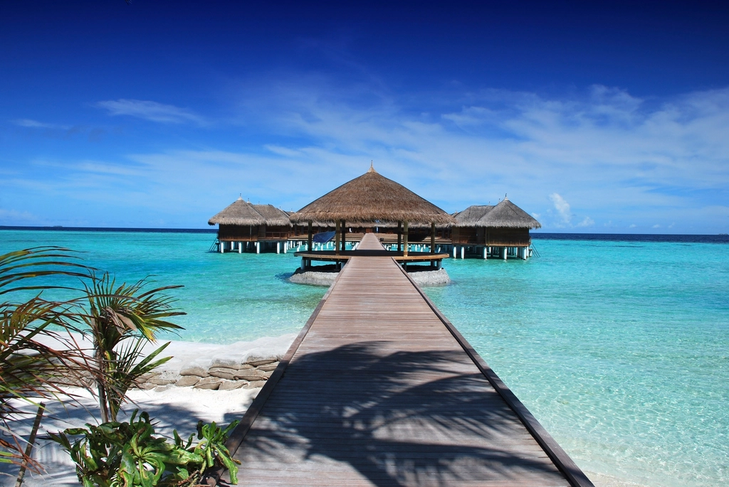 Beautiful overwater bungalow in Maldives with clear turquoise water.